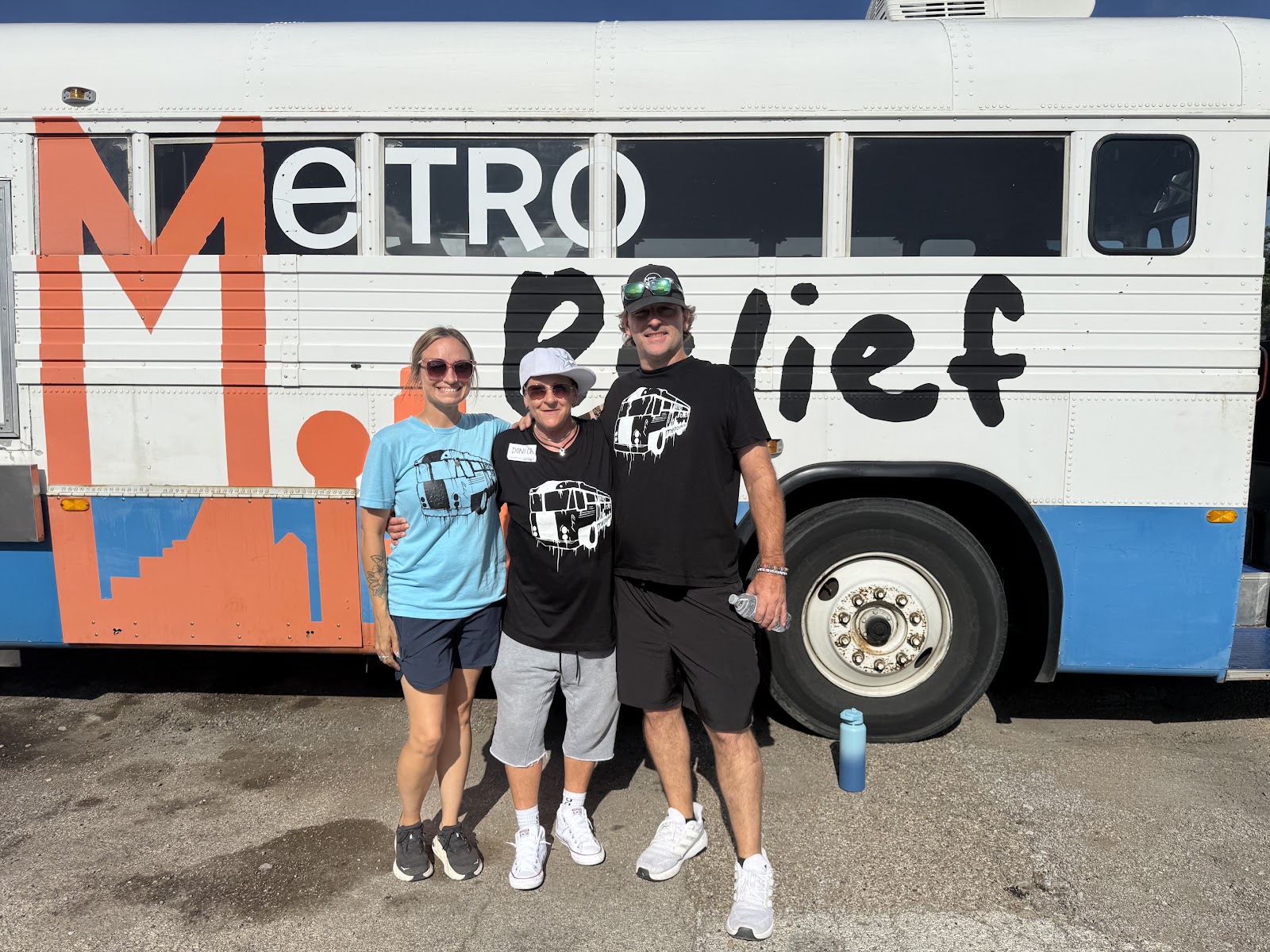 Donica standing with members of the Metro Relief team in front of a Metro Relief outreach bus